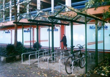 Eine grüne Fahrradüberdachung mit mehreren Fahrradanlehnbügeln