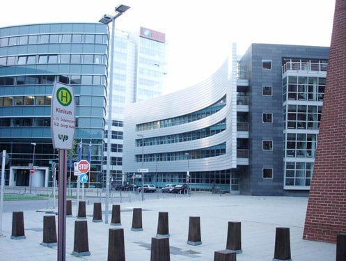 Ein Haltestellenschild vor einer großen Gebäudefassade