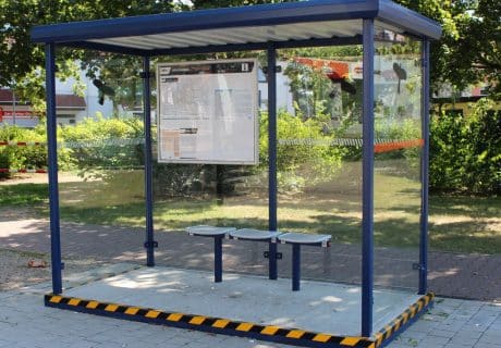 Ein blauer Raucherunterstand mit Bodenplatte am Wegesrand