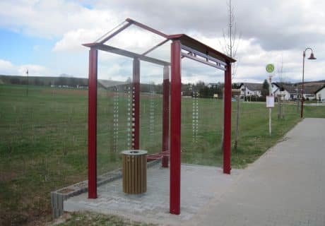 Eine rote zweifeldrige Wartehalle am Wegesrand