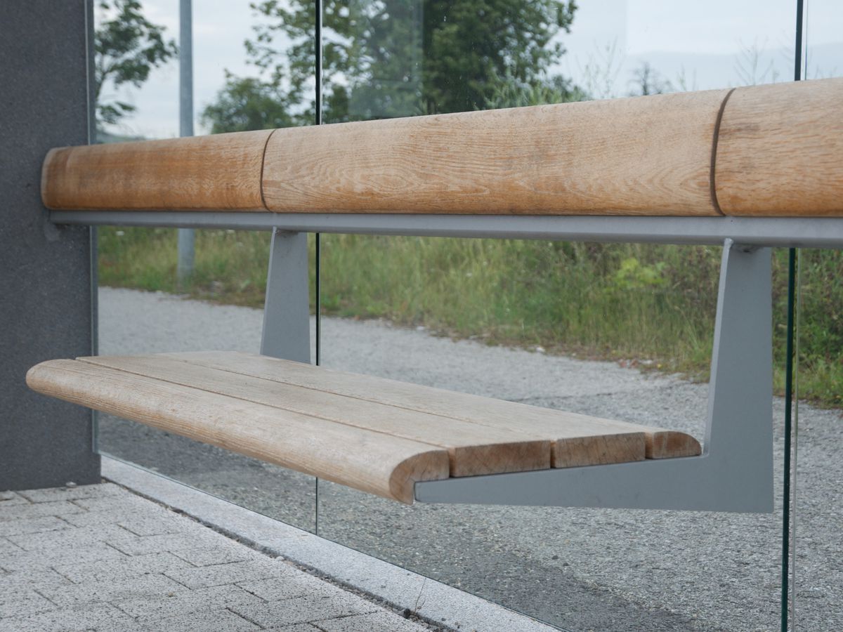 Eine Holzbank in einer Wartehalle