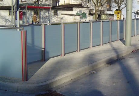 Eine Geländerreihe am Straßenrand mit Handlauf und Spritzschutz