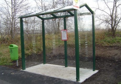 Eine dunkelgrüne zweifeldrige Wartehalle mit Betonbodenplatte