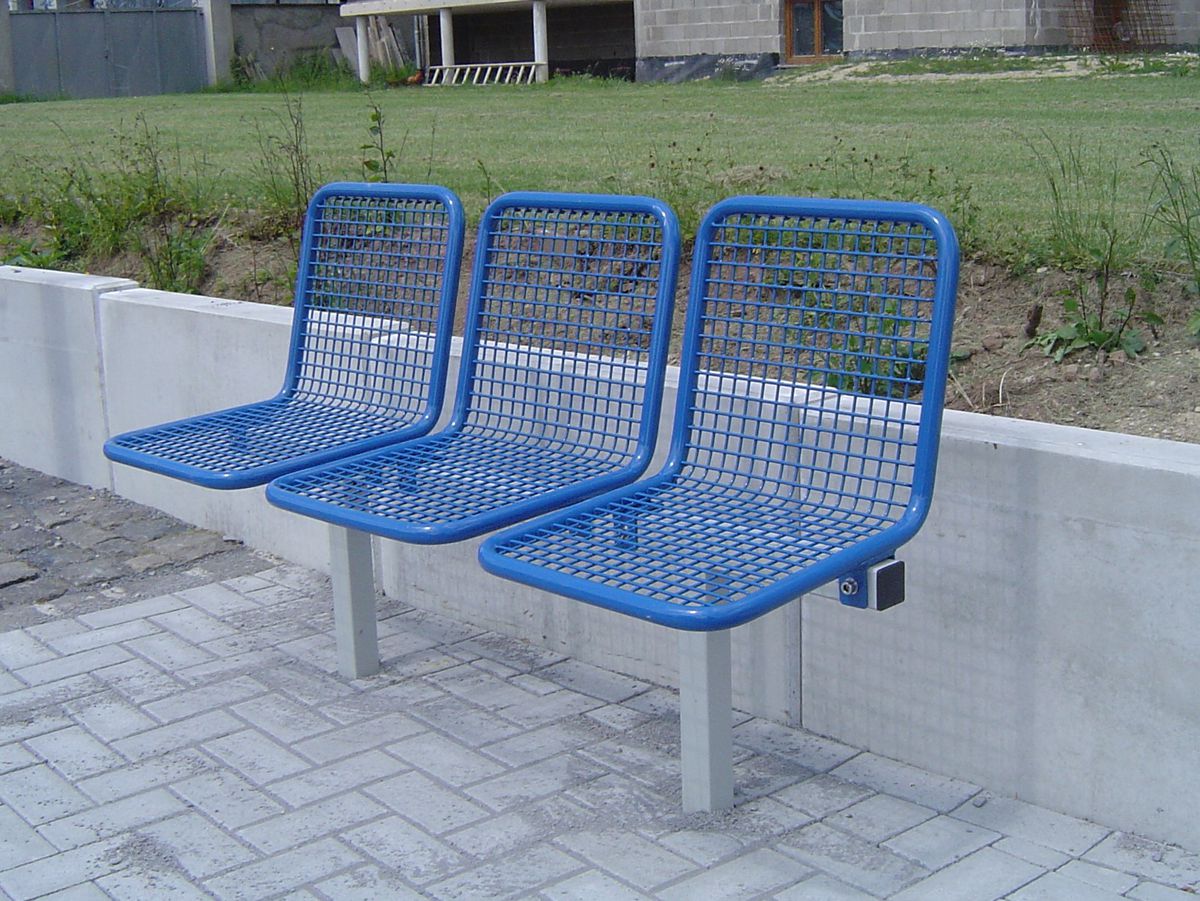 Drei blaue Drahtgittersitze vor einer Wiese