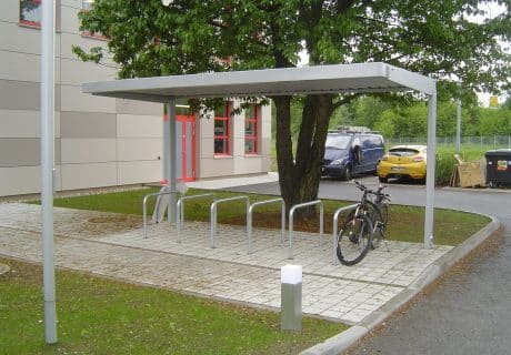 Eine Fahrradüberdachung mit mehreren Fahrradbügeln am Straßenrand