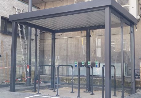 Eine Fahrradüberdachung mit mehreren Fahrradanlehnbügeln und Lademöglichkeit