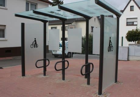 Eine Fahrradüberdachung am Straßenrand mit undurchsichtigen Scheiben