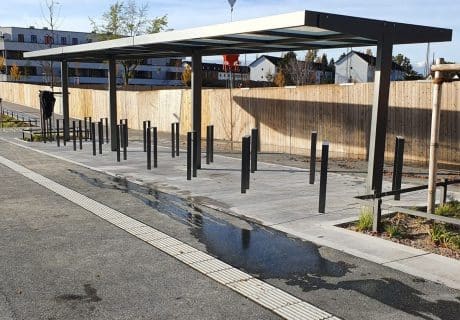 Eine Fahrradüberdachung mit mehreren Fahrradanlehnbügeln am Straßenrand