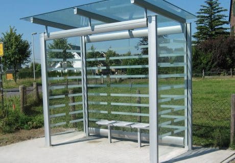 Eine graue zweifeldrige Wartehalle mit Scheibendekor und Drahtgittersitzbank