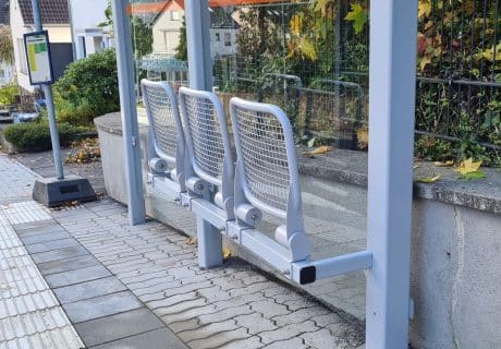 Eine hellblaue Klappsitzbank in einer Wartehalle