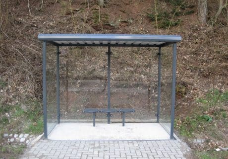 Eine graue zweifeldrige Wartehalle am Wegesrand