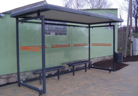 Eine graue dreifeldrige Wartehalle vor einem grünen Gebäude