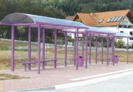 Eine lilafarbene an die Gefällelage angepasste Wartehalle am Straßenrand
