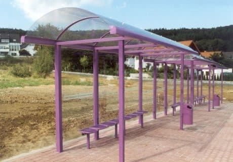 Eine lilafarbene Wartehalle als Reihenanlage am Straßenrand