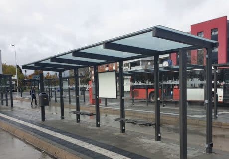 Eine graue fünffeldrige Wartehalle mit Fahrplanvitrine, Abfallbehälter und Sitzbänken