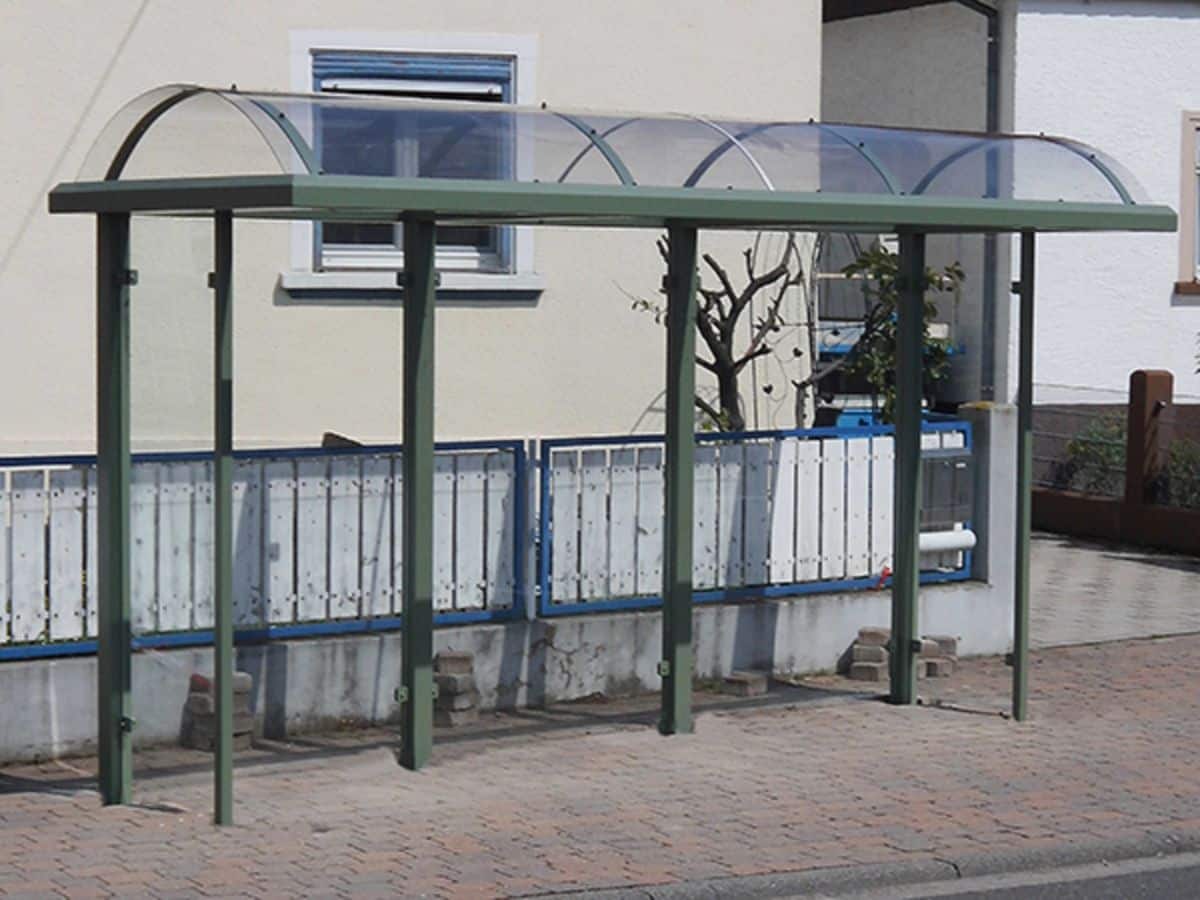 Eine grüne Wartehalle als Reihenanlage am Straßenrand