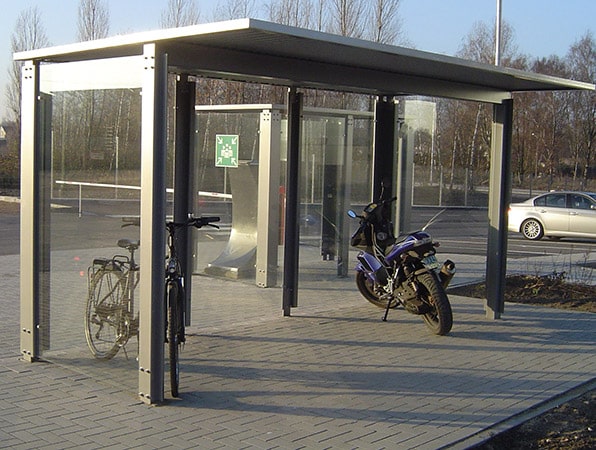 Eine Fahrradüberdachung am Straßenrand mit je einem Fahrrad und Motorrad