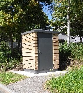 Eine freistehende Personaltoilette mit Holzwandverkleidung