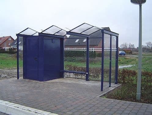 Eine blaue Personaltoilette an einer Wartehalle am Straßenrand