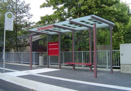 Eine graue vierfeldrige Wartehalle am Straßenrand mit der Aufschrift "Im Samelsfeld"