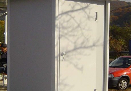 Eine Person sitzt in einer Wartehalle am Wegesrand