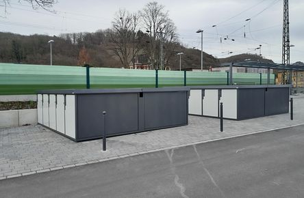 Mehrere Fahrradboxen vor einem Bahnhof